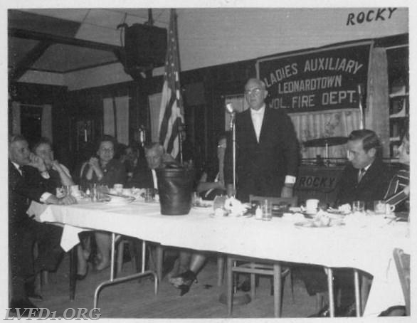 1970: Charles Fenwick presents leather bucket that once hung under porch of the St. Mary's Hotel.